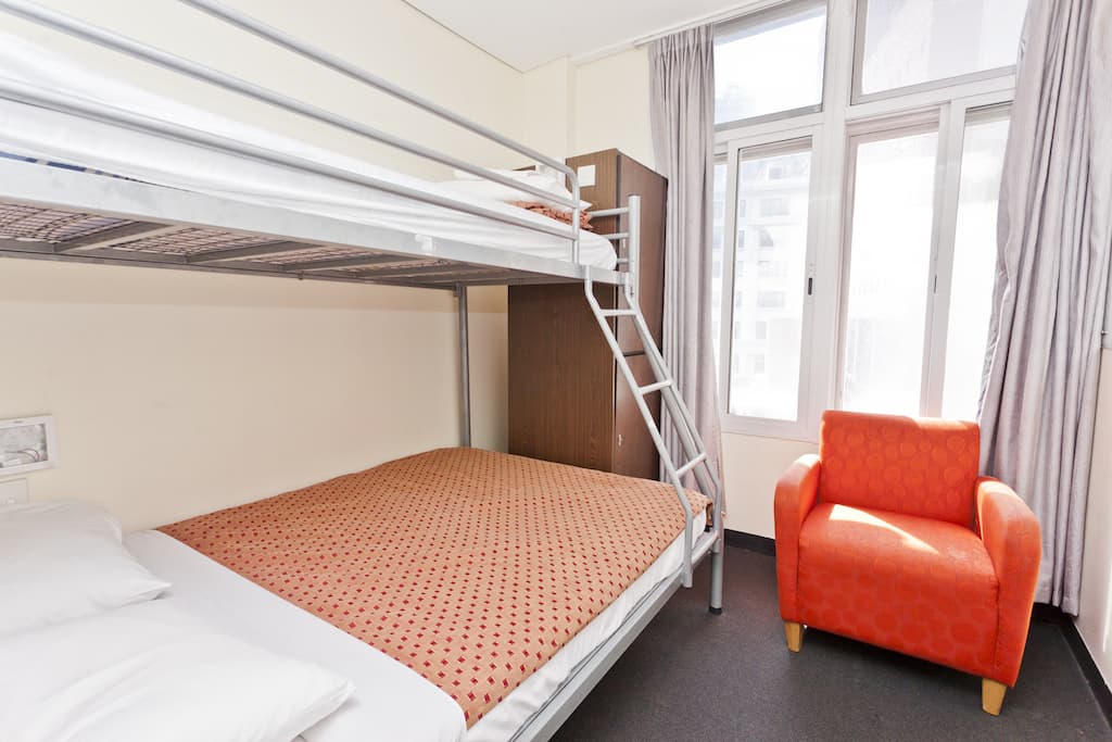 Private room with bunk bed and armchair